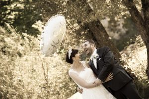 Hochzeitspaar im Wald mit großem, beschriebenen Luftballon, lachen lauthals