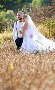 Hochzeitstag: Ehepaar steht in einem Kornfeld, mit Blick in die Weite schweifend