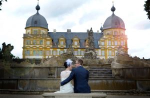 Ehepaar sitzt vor Schloss Seehof